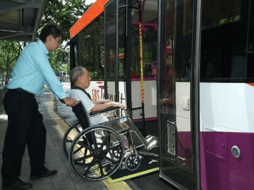 A man in a wheelchair boarding a public bus in Singapore, highlighting the city's barrier-free and wheelchair-friendly transport system.